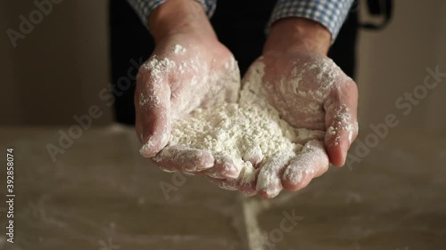 Baker show us a flour in his hands.