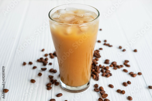 .Iced coffee in a glass On a white wooden background