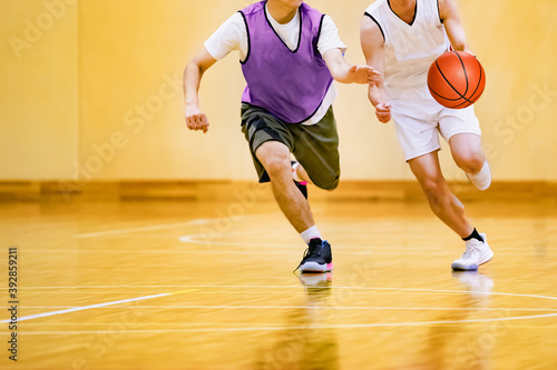 体育館でバスケットボールをする学生 © taka