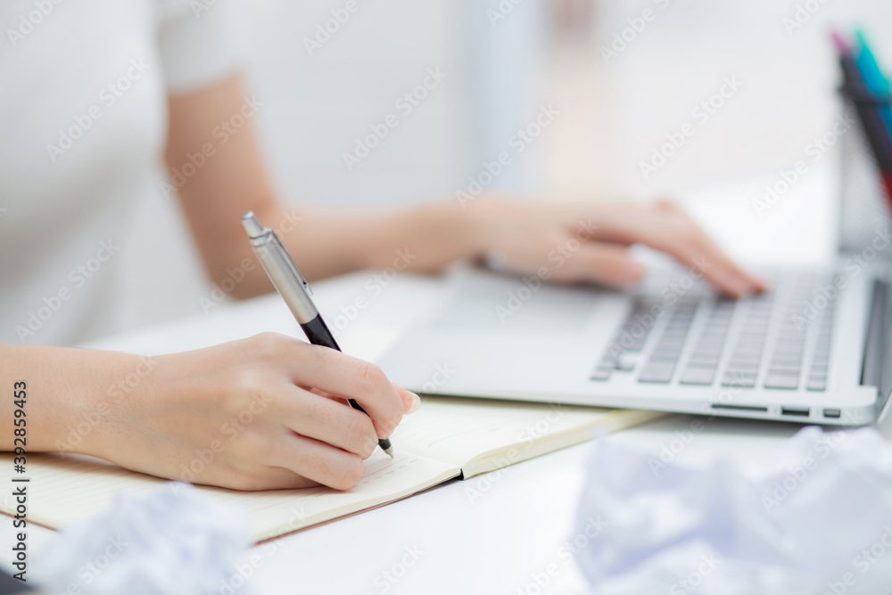 Closeup hand of young asian woman work and writing for planning and using laptop computer on table at home, girl thinking idea and creative, finance and communication, freelance and business concept. Closeup hand of young asian woman work and writing for planning and using laptop computer on table at home, girl thinking idea and creative, finance and communication, freelance and business concept.