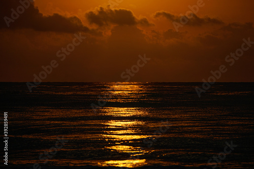 Beautiful golden beach sunrise on the Mediterranean coast with sun reflection. Clouds. Golden hour.