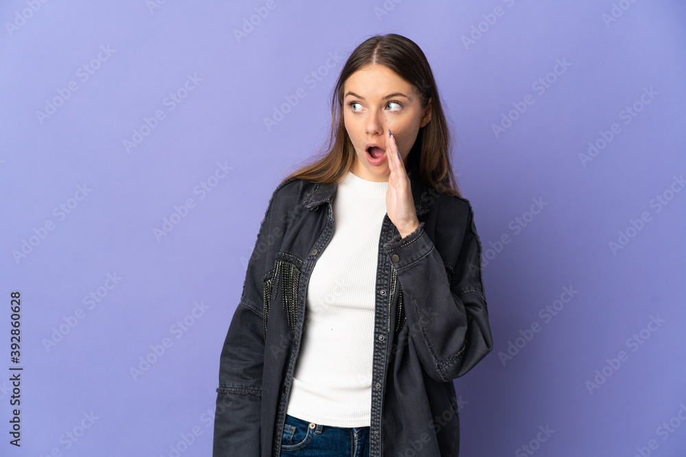 Young Lithuanian woman isolated on purple background whispering something with surprise gesture while looking to the side Young Lithuanian woman isolated on purple background whispering something with surprise gesture while looking to the side