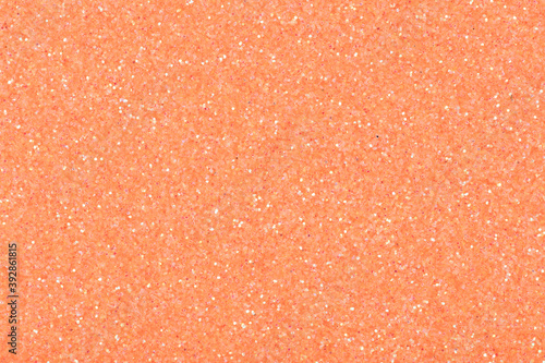 Glitter background in light peach tone, shiny texture for design.