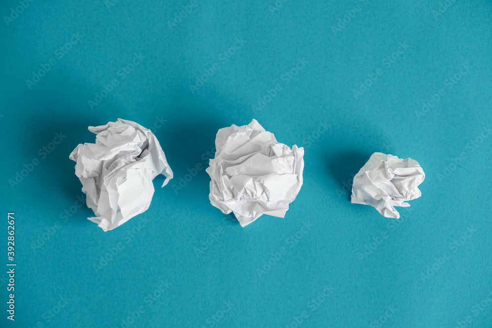 Crumpled paper balls on a blue background. Minimalist concept. Top view. Copy, empty space for text Crumpled paper balls on a blue background. Minimalist concept. Top view. Copy, empty space for text