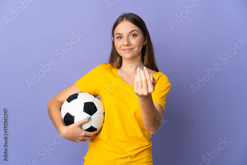 Young Lithuanian football player woman isolated on purple background inviting to come with hand. Happy that you came © luismolinero