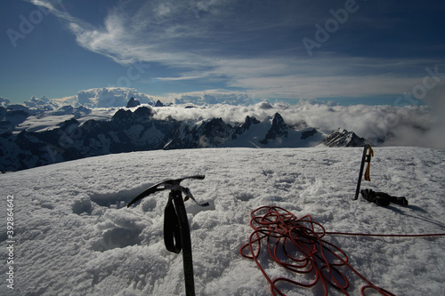 mountaineering equipment on the peak of Pigne d`Arolla with ice axe and rope looking toward Matterhorn in the distant background