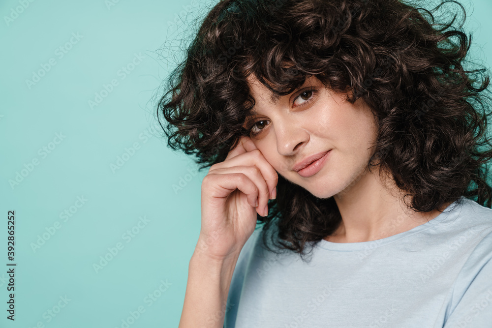 Caucasian serious curly girl posing and looking at camera Caucasian serious curly girl posing and looking at camera
