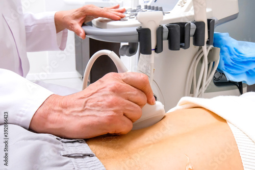 Adult doctor diagnoses human kidneys using ultrasound
