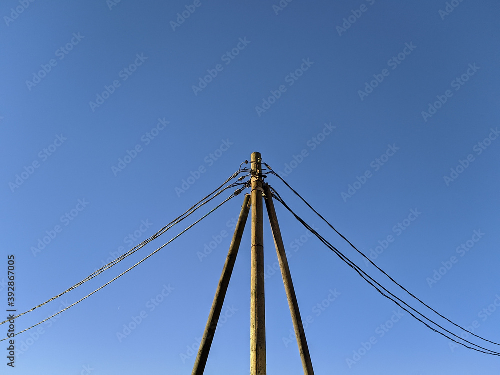 Fototapeta premium electric pole with wires against the blue sky