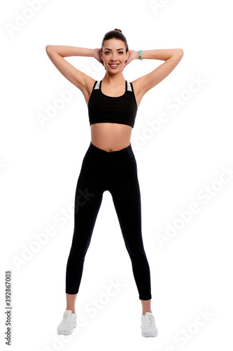 Fit strong sportswoman stretching hands on white isolated background. Fitness female doing physical exercise and smile. Healthcare and weight loss concept