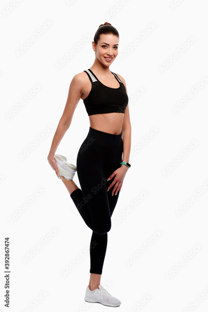 Slim strong athletic woman in sport wear doing stretching exercise in white isolated background Slim strong athletic woman in sport wear doing stretching exercise in white isolated background