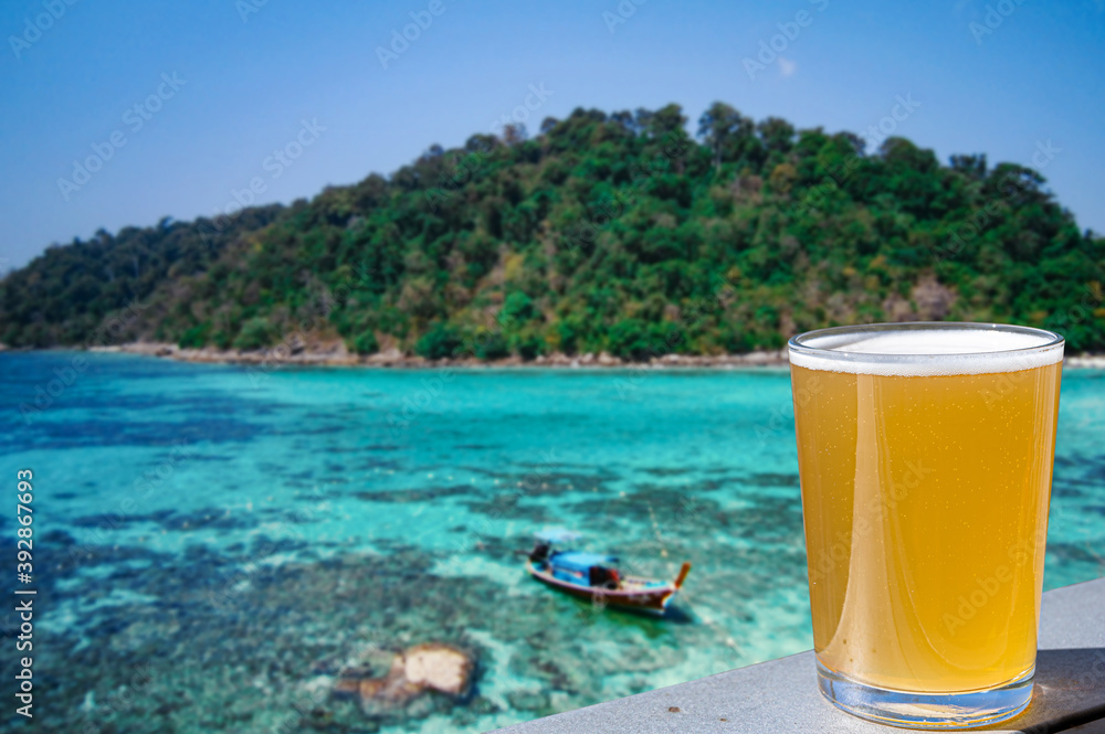 Light beer against turquoise ocean and green island. Vacation in tropical countries. Light beer against turquoise ocean and green island. Vacation in tropical countries.
