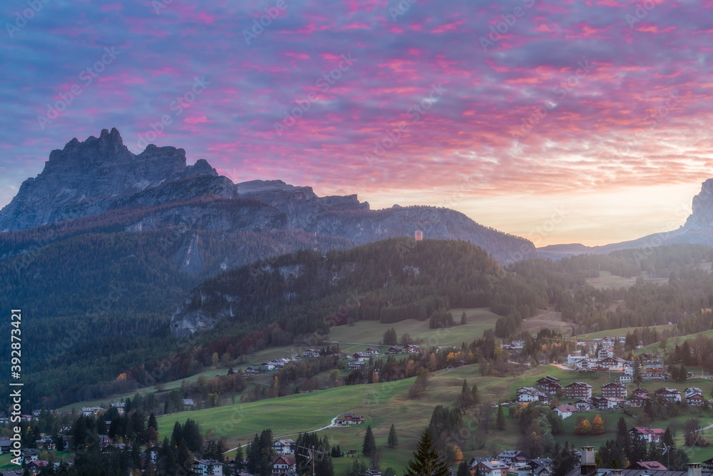 Small town in the Dolomites and mountains in the distance at dusk, Cortina