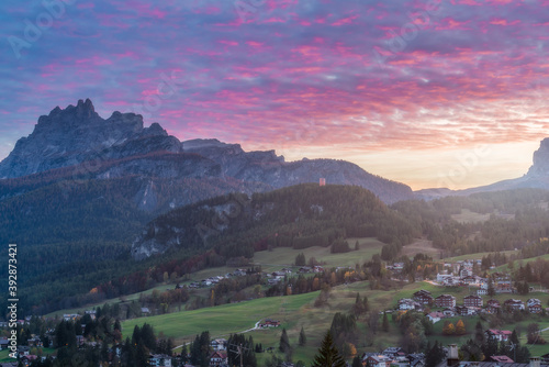 Small town in the Dolomites and mountains in the distance at dusk  Cortina