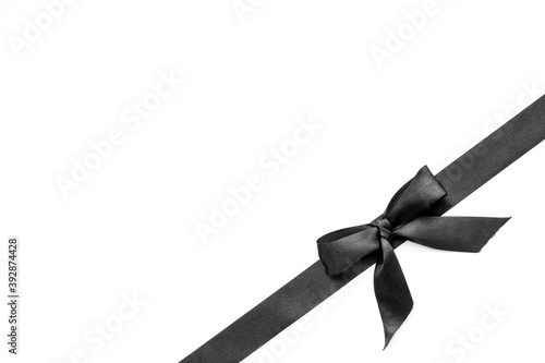 Black ribbon with bow isolated on white. Top view, copy space