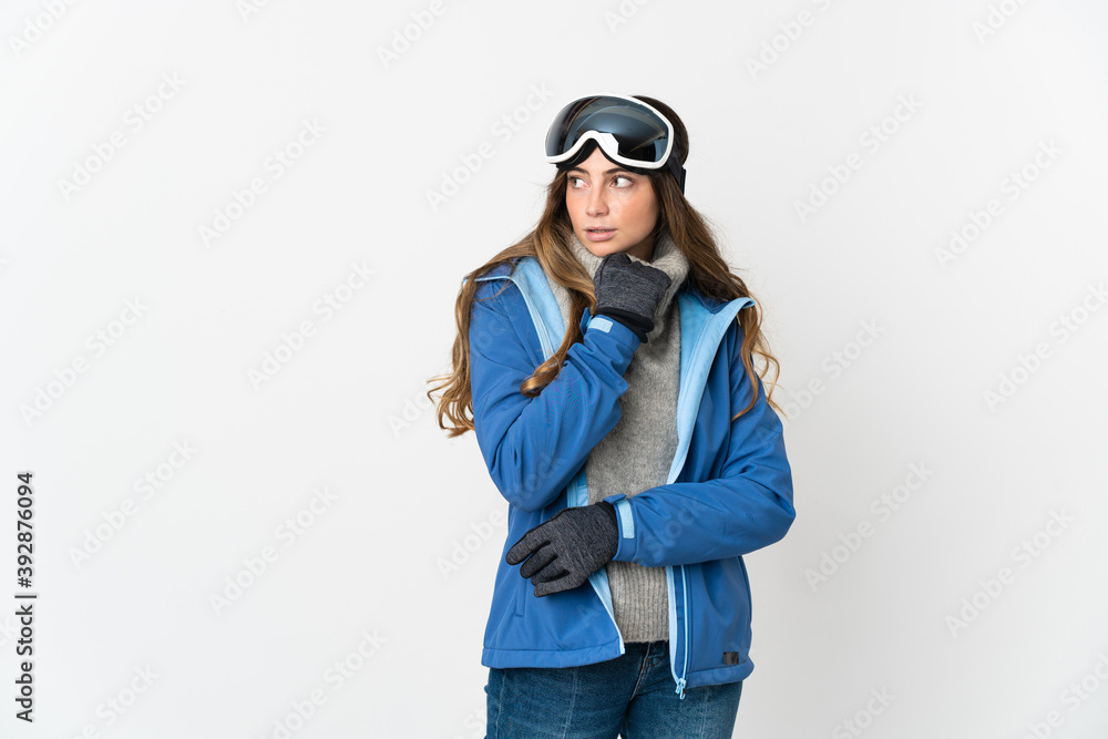 Skier girl with snowboarding glasses isolated on white background having doubts and thinking Skier girl with snowboarding glasses isolated on white background having doubts and thinking