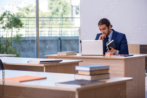 Young male teacher in suit in the classroom