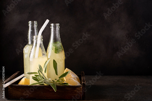homemade lemonade in small bottles with mint and spicy herbs