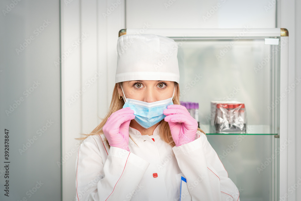 Female nurse or doctor wears protective gloves putting on medical face mask in the lab Female nurse or doctor wears protective gloves putting on medical face mask in the lab