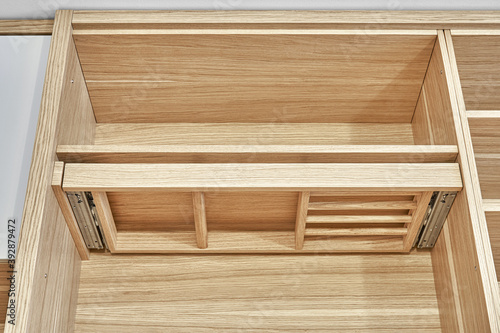 Modern wardrobe with slide out rack for coathangers. Detail of modern furniture © timltv