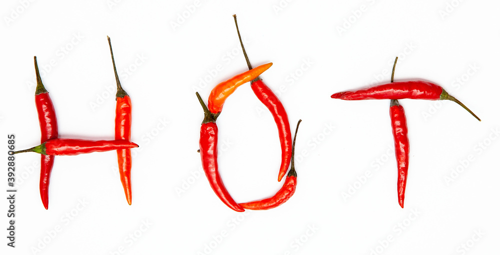 Word HOT made of Chili pepper isolated on white. Top view Layout of multicolor hot spicy peppers forming a word Word HOT made of Chili pepper isolated on white. Top view Layout of multicolor hot spicy peppers forming a word