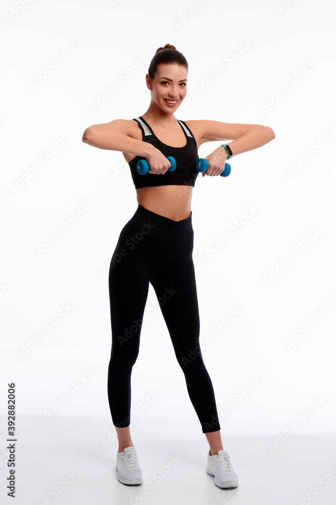 Attractive caucasian slim woman doing physical exercise using dumbbell isolated on white background Attractive caucasian slim woman doing physical exercise using dumbbell isolated on white background