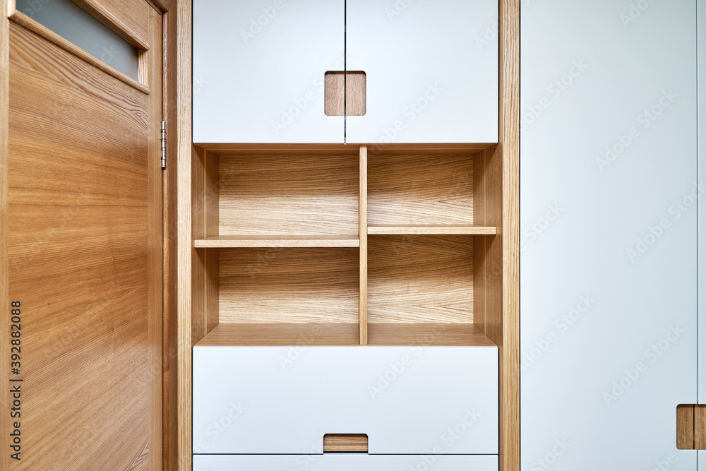 Modern wardrobe with finger pull design. Wooden wardrobe with light gray cabinet doors. Modern furniture - obrazy, fototapety, plakaty 