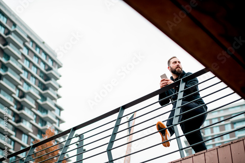 Young man with beard taking break from exercising outdoors