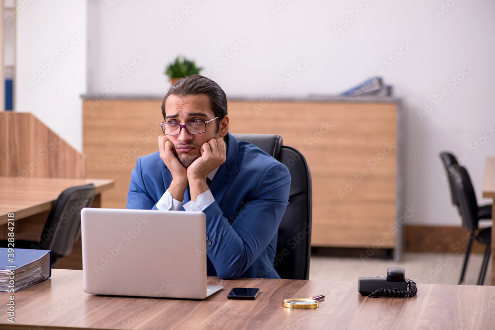 Young male employee sitting at workplace Young male employee sitting at workplace