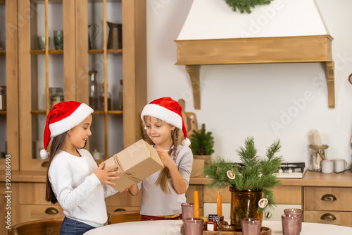 Happy children with gifts. Twins, two little sisters, two similar girls giving presents. Holiday and Christmas concept.