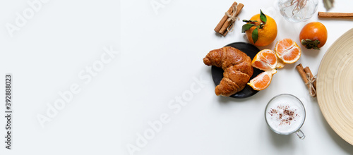Composition with New Year's assortments on a white table. Christmas mood. over white background coffee croissant tangerines and cinnamon. Place for inscription layout. Flat lay