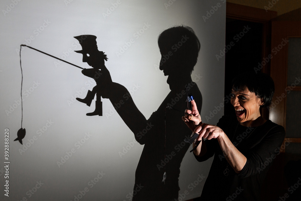 play shadow projected against a white background. a homeless man with a rod fishing play shadow projected against a white background. a homeless man with a rod fishing