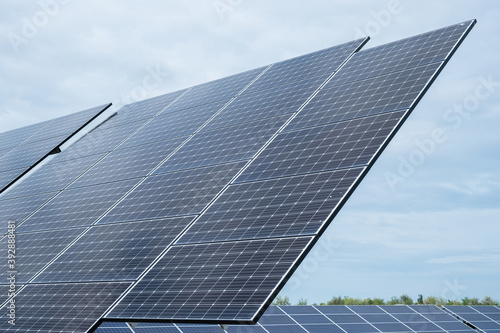 Many solar panels closeup at sunny day - green energy technology as background © bartoshd