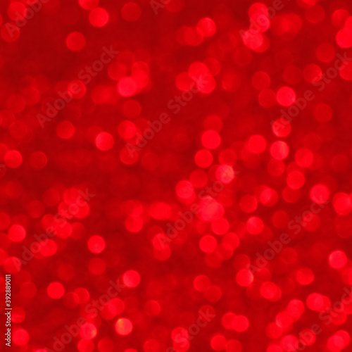 Red shimmering light, sequins sparks and glittering glow foil background.
