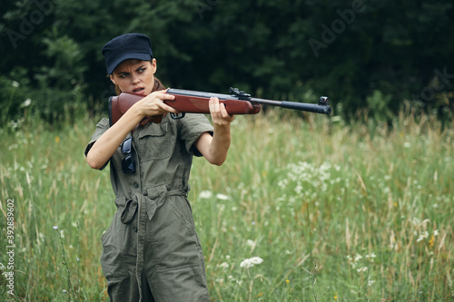 Woman Holding a weapon aiming hunting fresh air green overalls