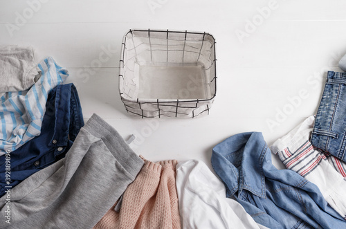 A group of organic cotton clothing set on a white table is ready to be folded into white baskets.The concept of closet organization. Colors in the Scandinavian style. Using the Komari method. photo