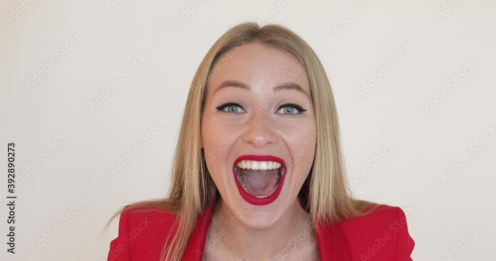 portrait of emotinal caucasian woman with red lips in red suit loudly say something on the camera isolated on white background portrait of emotinal caucasian woman with red lips in red suit loudly say something on the camera isolated on white background