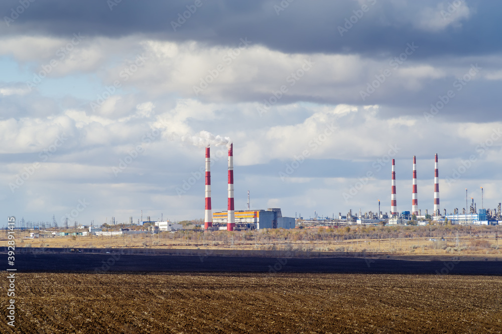 Autumn landscape with a plowed field, CHP and gas processing plant on the horizon. The picture was taken in Russia, in Orenburg Autumn landscape with a plowed field, CHP and gas processing plant on the horizon. The picture was taken in Russia, in Orenburg