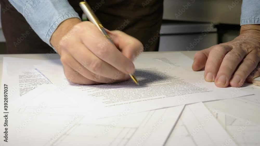 Man reviewing and signing document Man reviewing and signing document