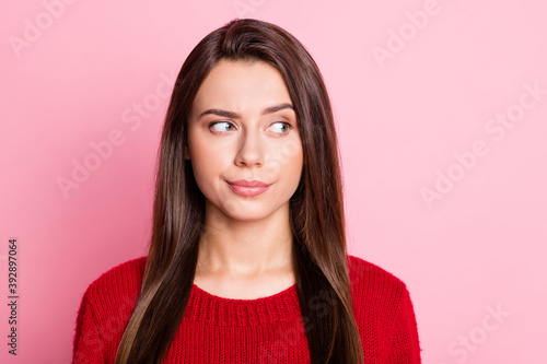 Photo portrait of suspicious unsure girl with straight brunette hair looking at side isolated on pink color background