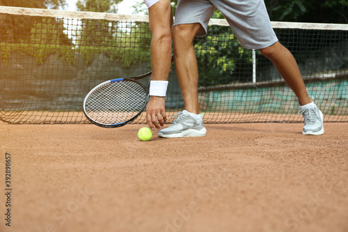 Sportsman playing tennis at court on sunny day, closeup © New Africa