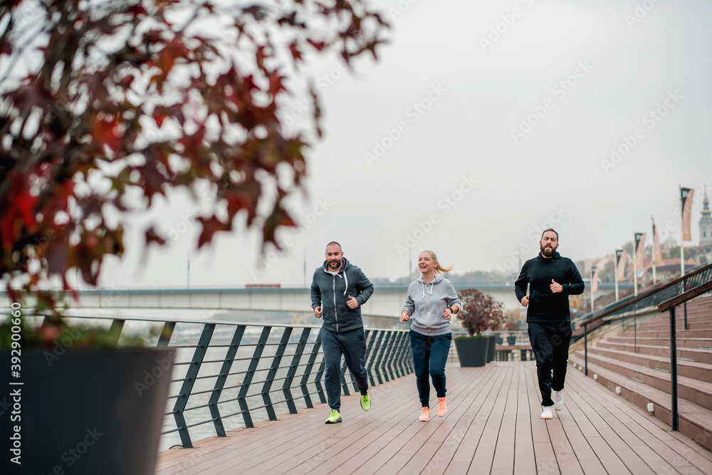 Obraz premium Small group of people running in autumn day 