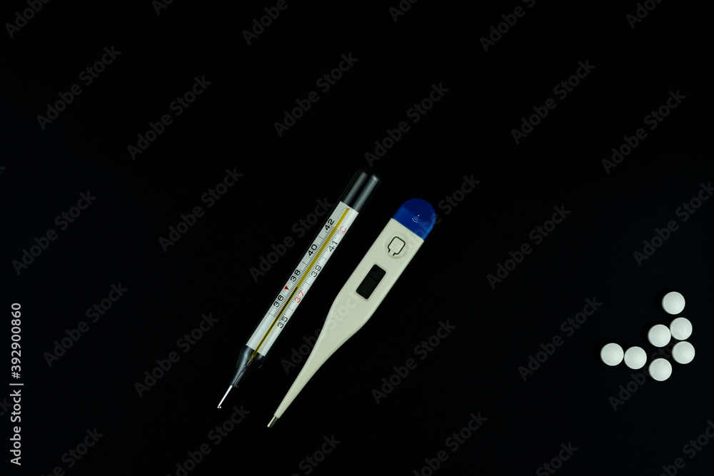 Electronic and mercury thermometer and some white pills. Electronic and mercury thermometer and some white pills.