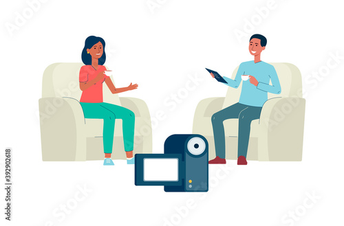 Two people at video interview in front of camera with tea and armchairs