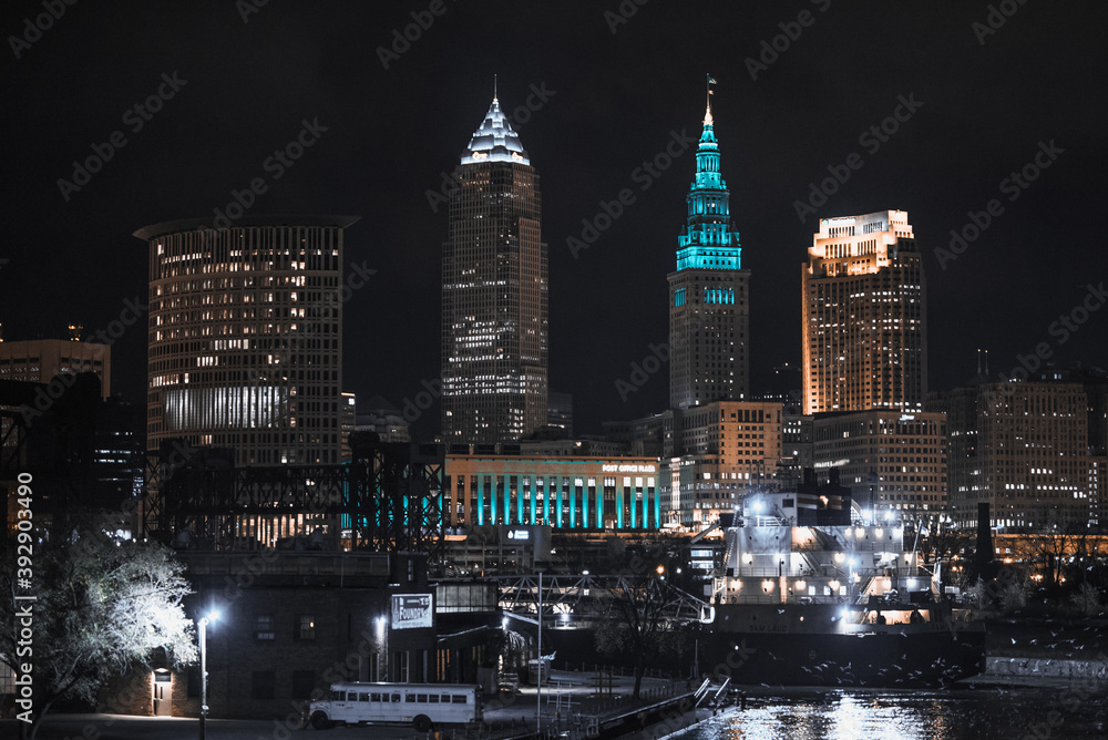 Cleveland ohio skyline at night with a ship on the cuyahoga river