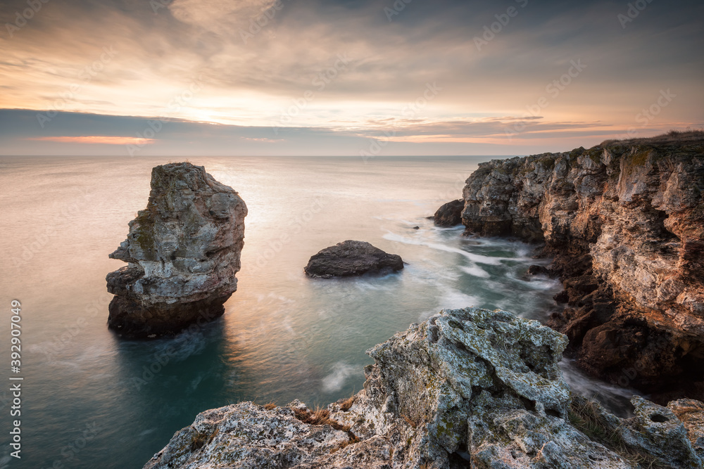 Magnificent sea sunrise at the rocky Black sea coast with a lonely rock in the sea