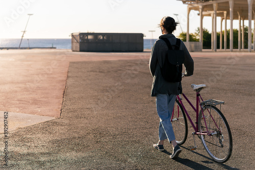 unrecognizable young girl walking with retro bike