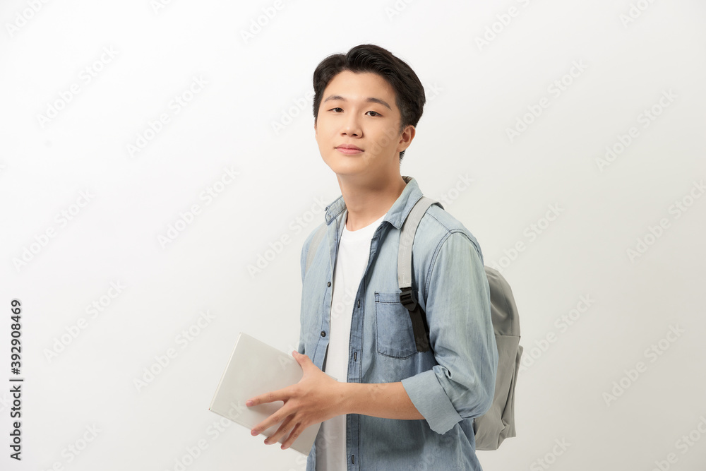 Portrait of smiling young college student with books and backpack against white background Portrait of smiling young college student with books and backpack against white background