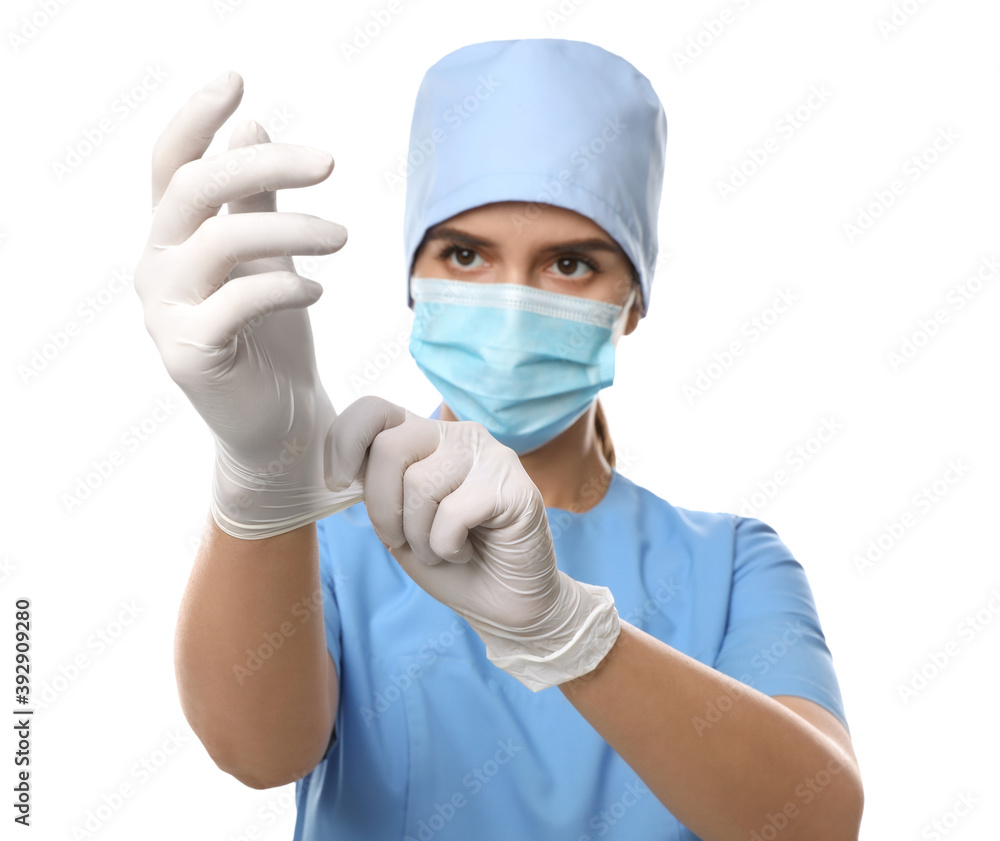 Doctor in protective mask and scrubs putting on medical gloves against white background Doctor in protective mask and scrubs putting on medical gloves against white background