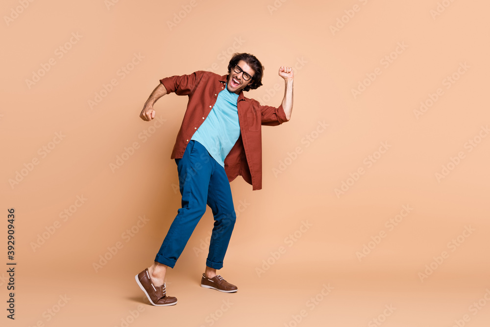 Fototapeta premium Full length profile photo of guy dance open mouth wear glasses brown t-shirt trousers shoes isolated beige color background